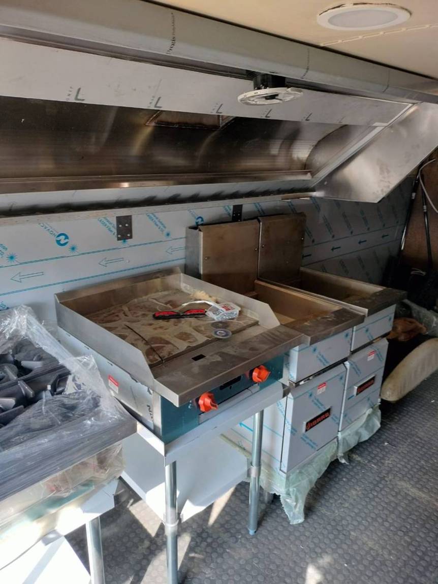 The real bus kitchen with stainless hood, griddle and fryers installed