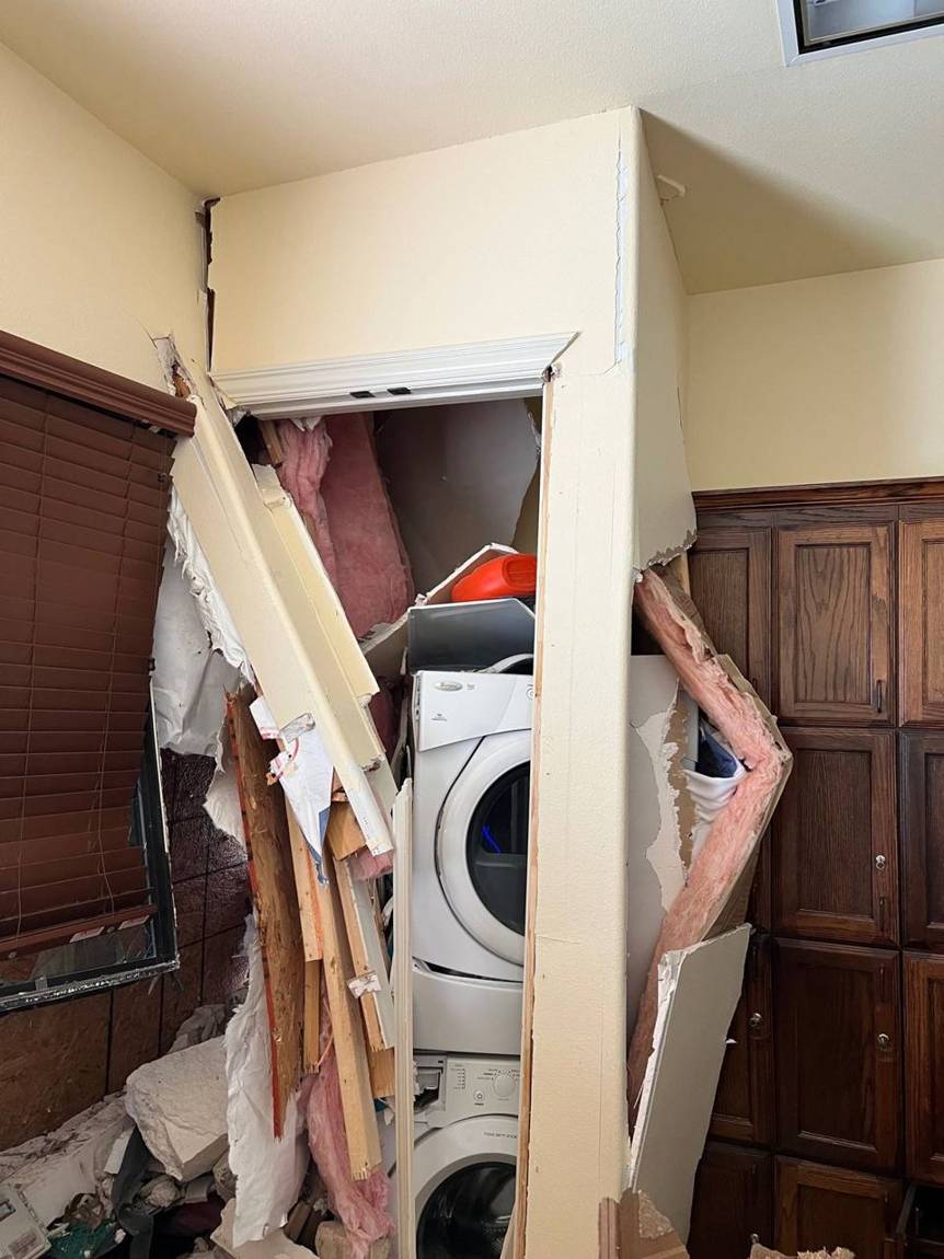 Interior wall and laundry closet torn open after the damage