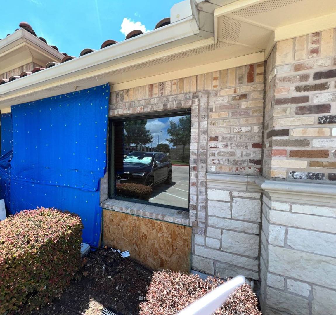 Exterior secured with tarp and boarding during repairs