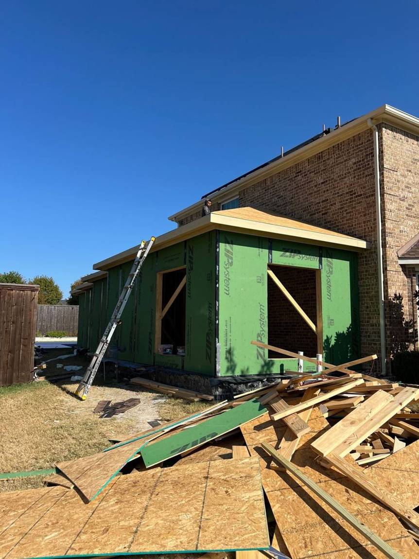 Roof decking going on with a crew member on the roof