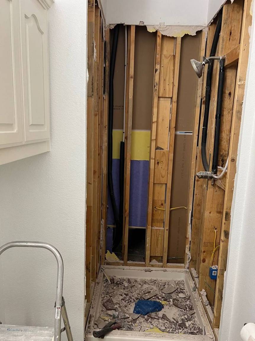 Old shower opened down to the framing and plumbing