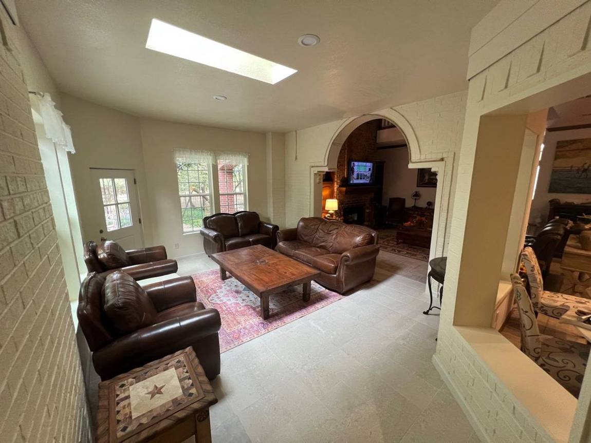 Finished room addition with skylight, tile floor, painted brick and a new arched opening