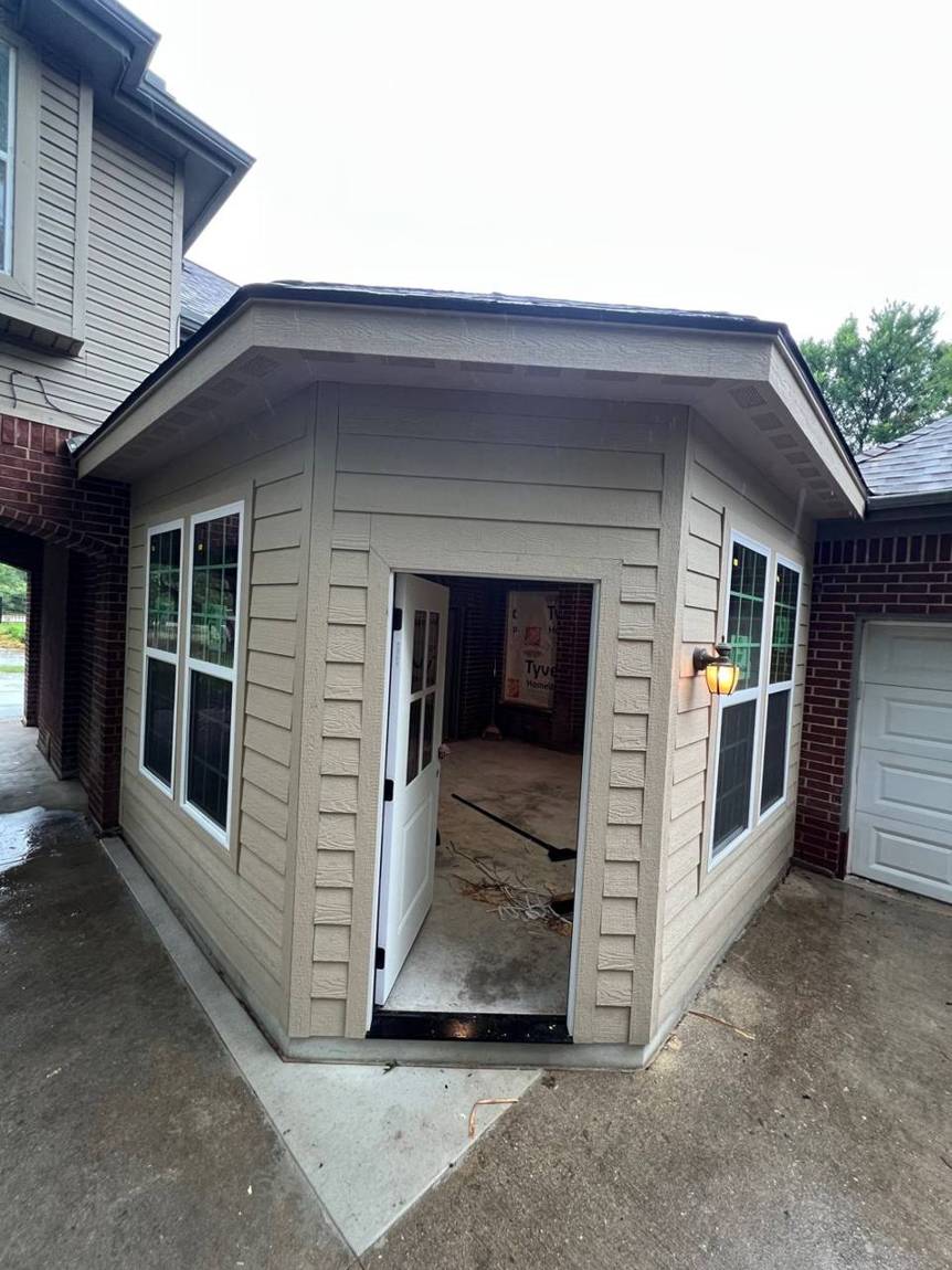 Exterior finished with siding, new windows, door and light