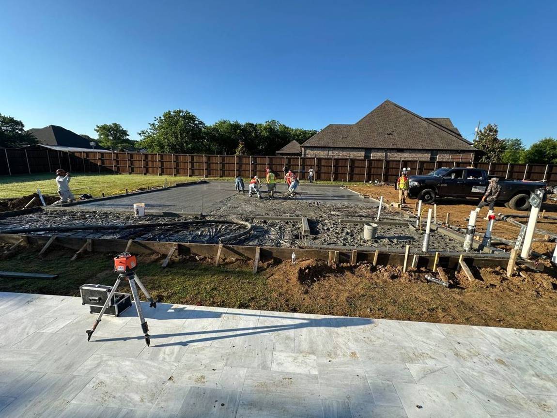 Full crew placing concrete with a laser level on site