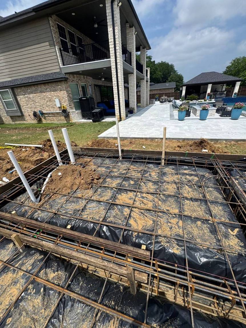 Forms, vapor barrier, rebar grid and plumbing stub-outs ready for inspection